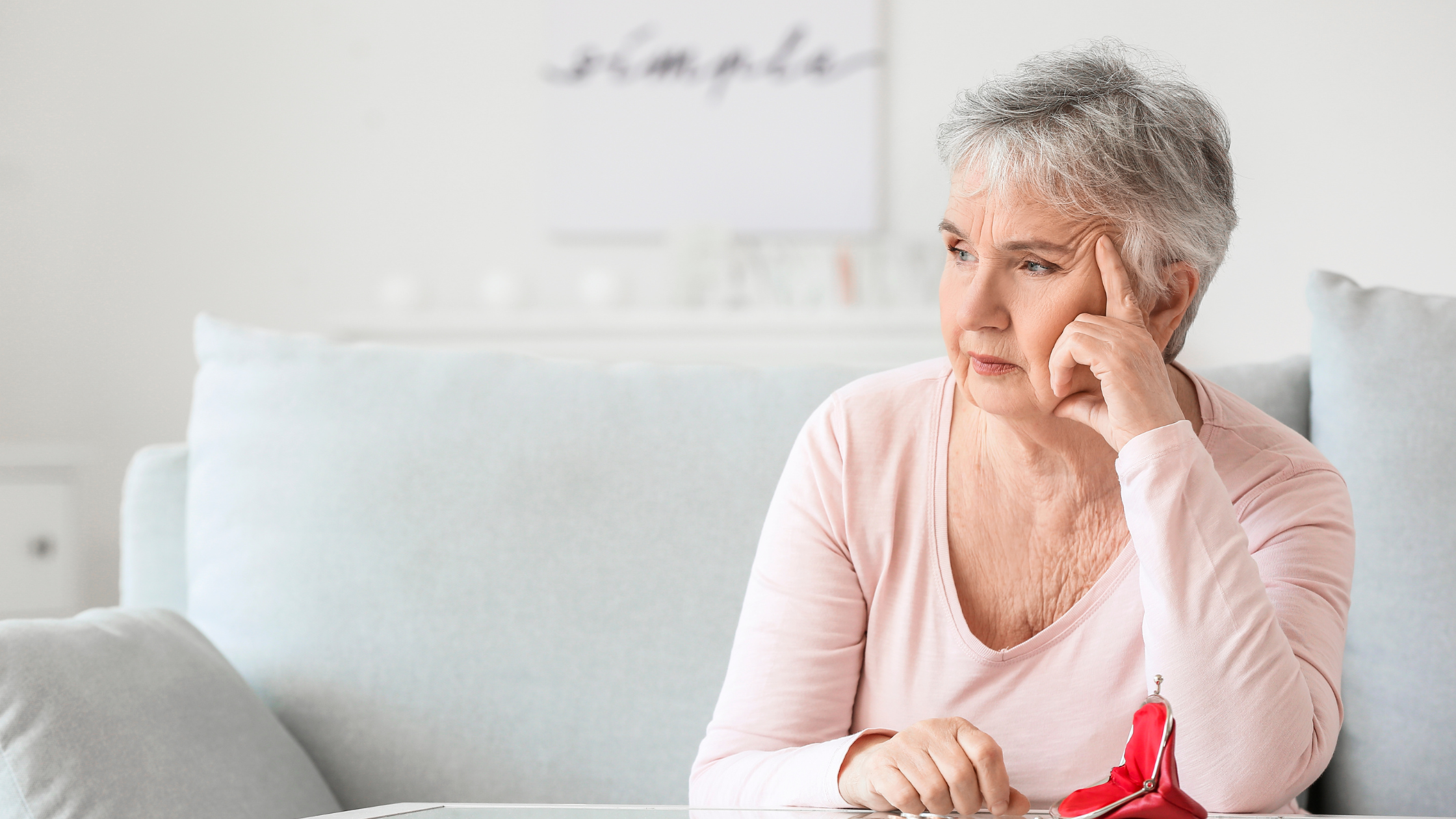 Seniorin denkt über Zukunft nach. Innovatives Notfallarmband mit automatischem Alarm bei einem Sturz.